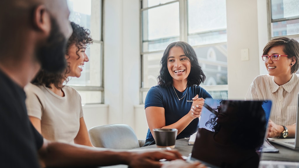 Business meeting, global company and teamwork diversity with laptop, black man and women in South African office. Smile, happy or creative people in communication, collaboration and strategy planning